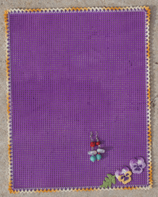 first of many pairs of earrings on the crocheted pansy and plastic canvas earring organizer