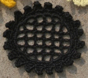 crocheted sunflower on a grid